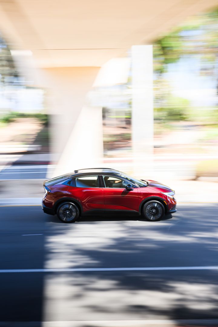 Right profile view of the 2026 Nissan LEAF driving under an overpass.