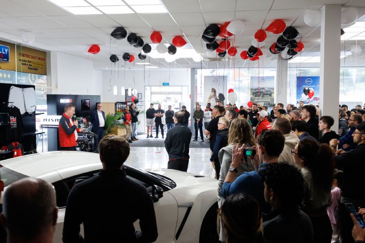 A side view of Aftersales director, Michael Hill with a microphone giving a speech to guests.
