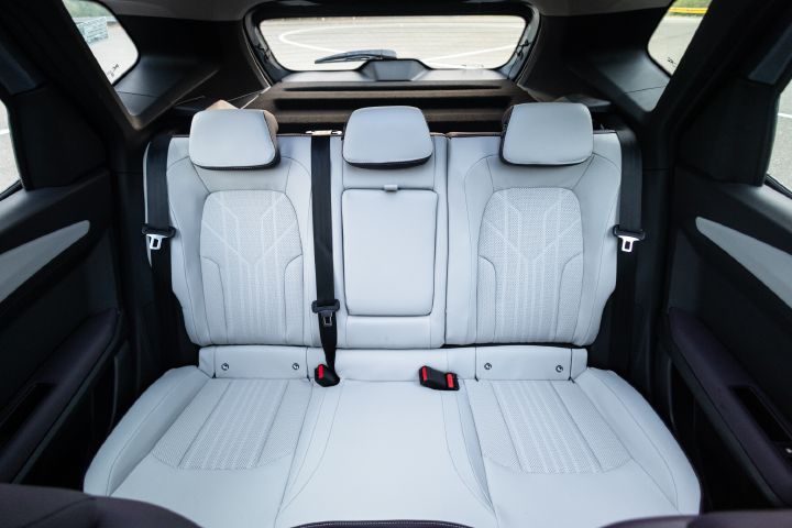Rear seating area with three seats, generous headroom and light-coloured upholstery.