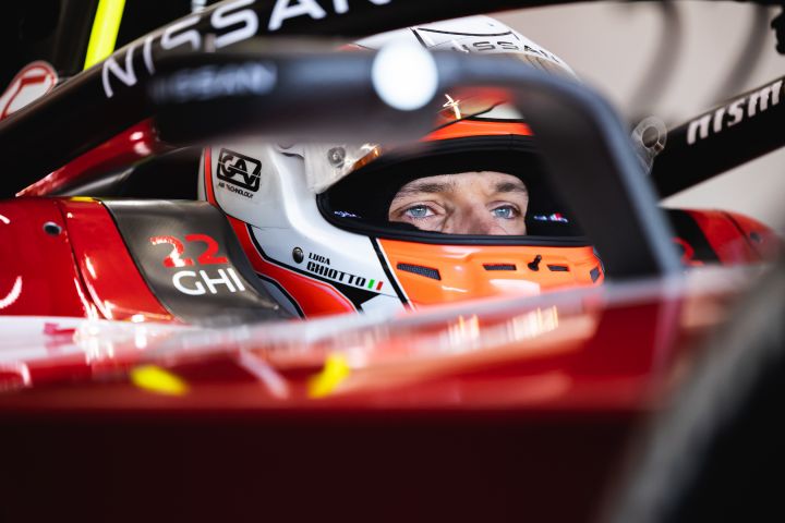Pilote de Formule E de Nissan avec un casque sur le siège conducteur d'une voiture de Formule E.