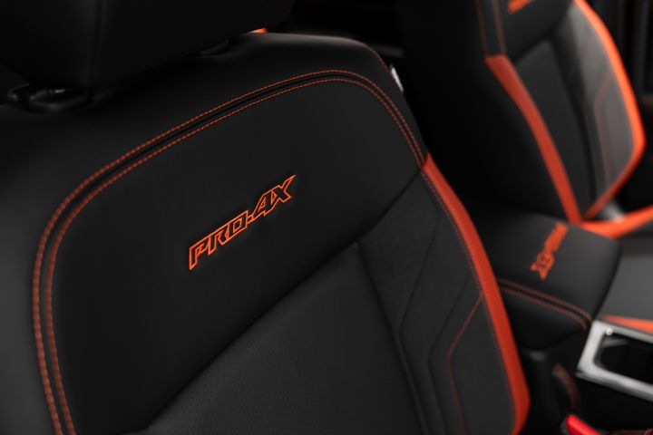 2026 Nissan Navara PRO-4X finished in Boulder Grey illustrating the front backrest with bright PRO-4X embroidery, perforated trim and red piping.