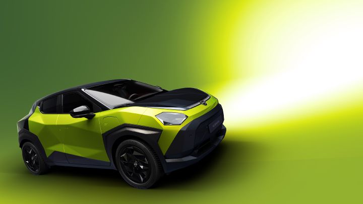 Against a bright green background, a Juke EV is positioned facing slightly forward, shown in a yellow-green color in a studio-like setting.