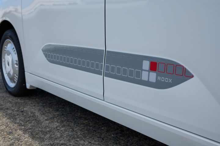 The side of the new Nissan Roox kei car features a side decal composed of a gray rectangle with red and white squares arranged in a row. The geometric pattern adds a visual accent to the vehicle’s body.