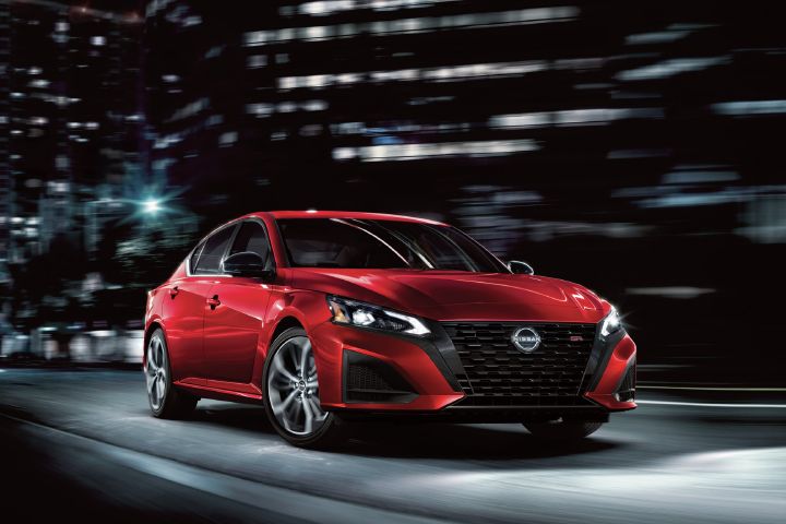 Front right 3/4 view of the 2027 Nissan Altima parked on city streets at night.