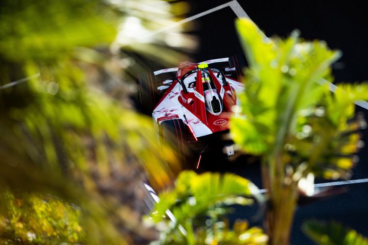 Blick aus der Vogelperspektive auf Oliver Rowland im Nissan Formel E Rennwagen auf der Rennstrecke in Monaco, wobei die Sicht durch einige Bäume leicht versperrt ist