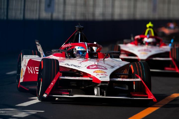Carro de corrida da Equipe Nissan de Fórmula E em curva durante disputa de prova