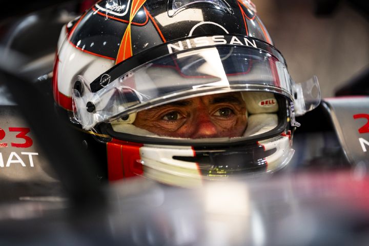 Norman Nato sitzt mit aufgesetztem Helm und hochgeklapptem Visier im Auto mit der Startnummer 23 in der Teamgarage, Nahaufnahme.