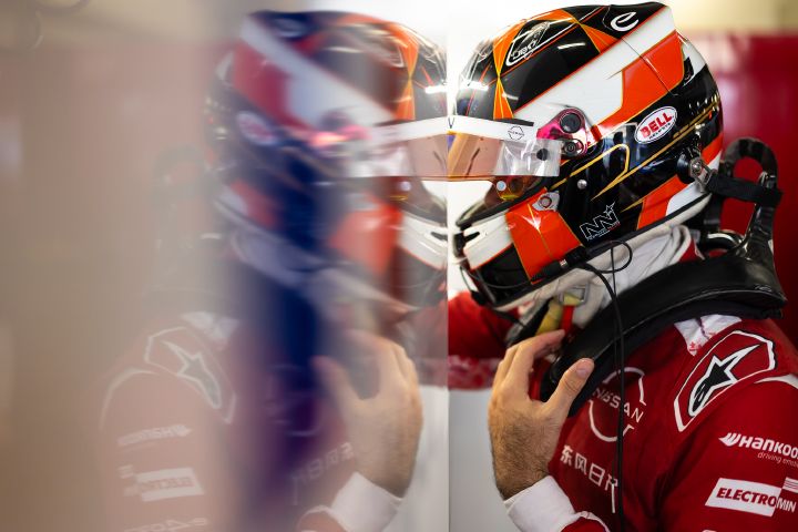 Norman Nato mit aufgesetztem Helm und hochgeklapptem Visier macht sich in der Teamgarage bereit für eine Trainingseinheit.