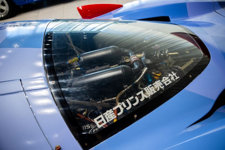 A close up of the engine within a blue Nissan R390 GT1 Le Mans race car.