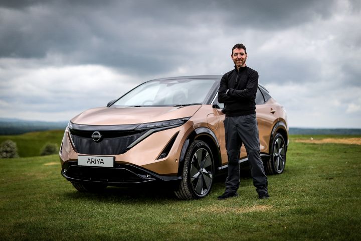 Man posing with a Nissan Ariya.