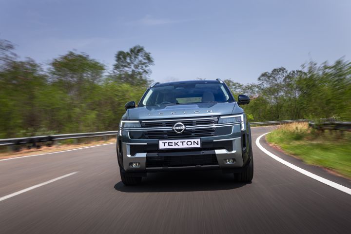 Nissan Tekton driving through a sweeping bend, showcasing its front design.