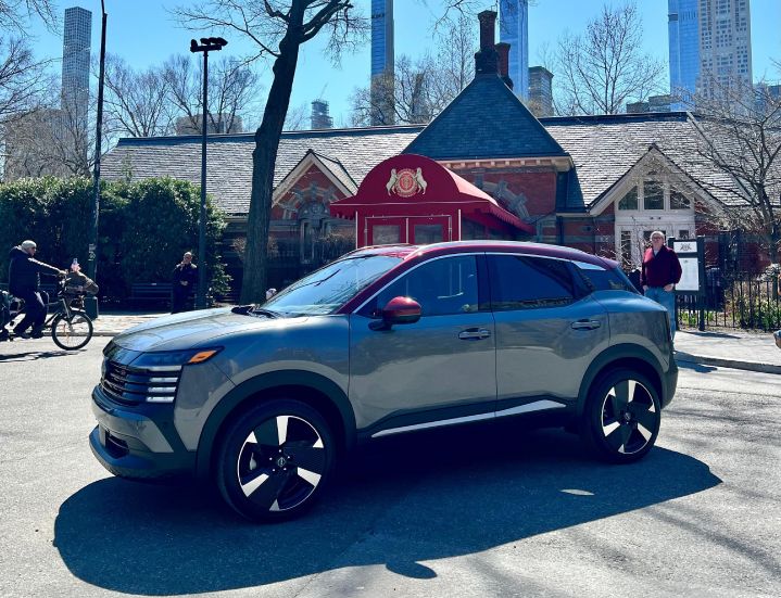 Al fondo restaurante neoyorkino Tavern on the Green, de Central Park, nueva Nissan Kicks 2025 bitono gris con Rojo de costado
