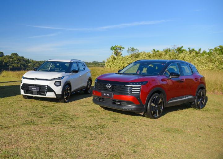Nissan Kait branco, no lado esquerdo da foto, com o Nissan Kicks vermelho, no lado direito. Os dois estão estacionados sobre um gramado