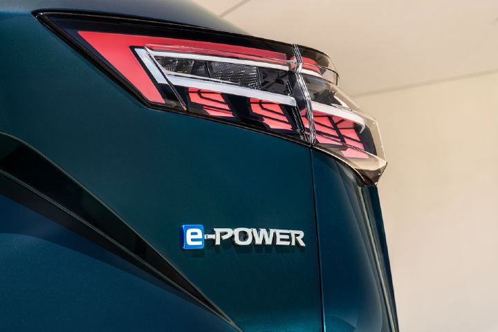 Imagem de detalhe do símbolo e‑POWER na traseira de um Nissan Qashqai azul escuro