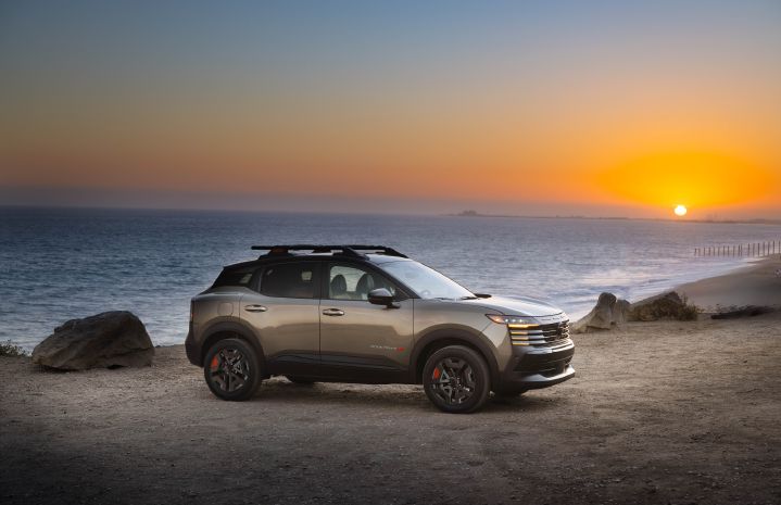 Front right 3/4 view of the 2027 Nissan Kicks Rock Creek park on a beach with the sun setting behind.