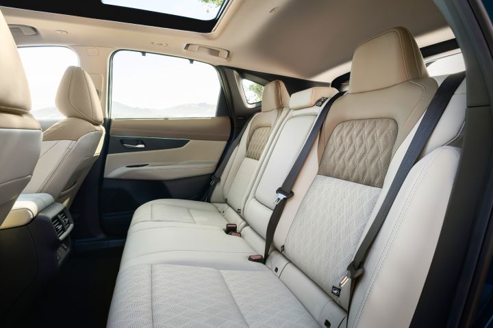 The light-colored leather rear passenger seats inside the 2025 Nissan Murano, light shines through the windows.
