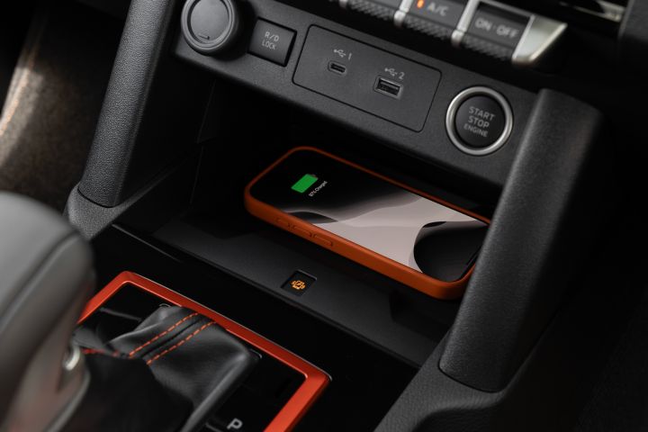 2026 Nissan Navara PRO-4X finished in Boulder Grey showing the lower console with wireless phone charging pad, USB ports, start-stop button and gear selector.