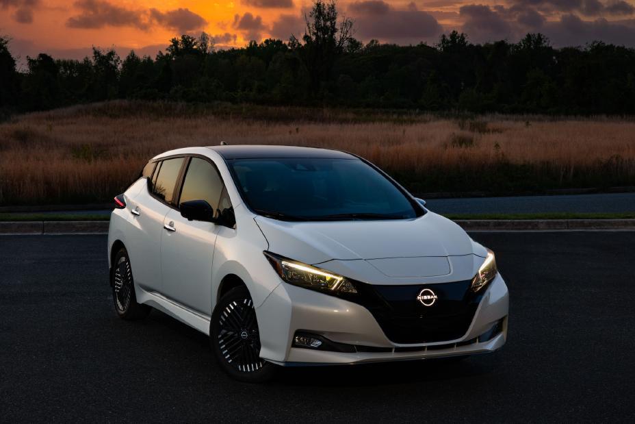 Front right ¾ view of a white 2025 Nissan LEAF parked along a desert highway.