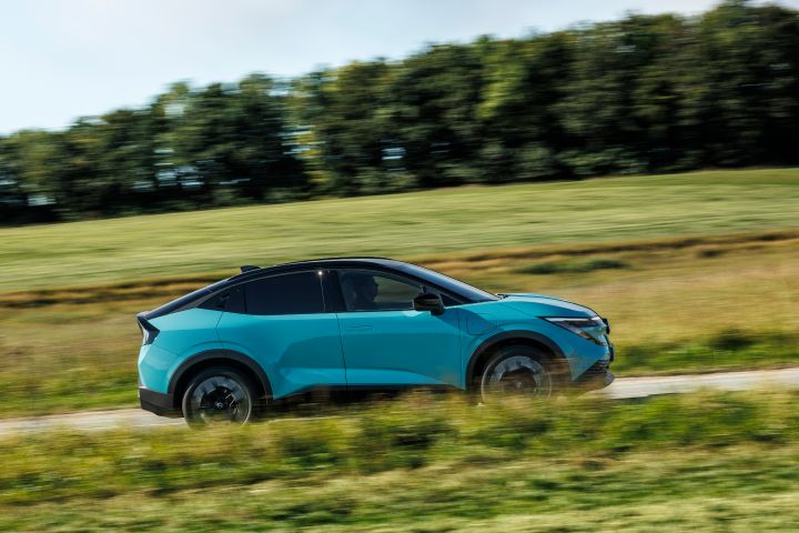 Seitliche Fahraufnahme eines türkisen Nissan LEAF auf einer Landstraße in Dänemark