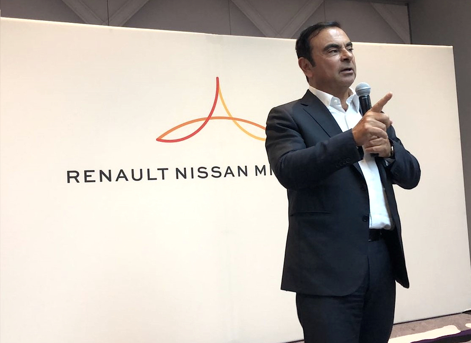A man giving a speech at an event for Renault Nissan Mitsubishi.