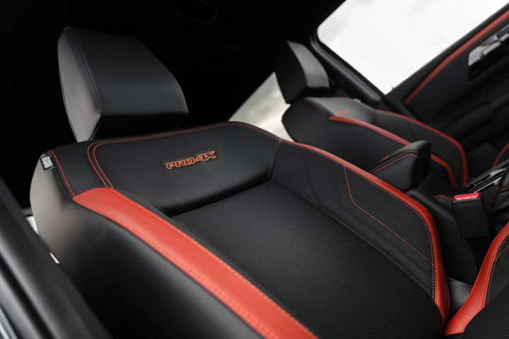 2026 Nissan Navara PRO-4X finished in Boulder Grey showcasing the front seatback with orange PRO-4X embroidery, perforated trim and bold red bolsters.