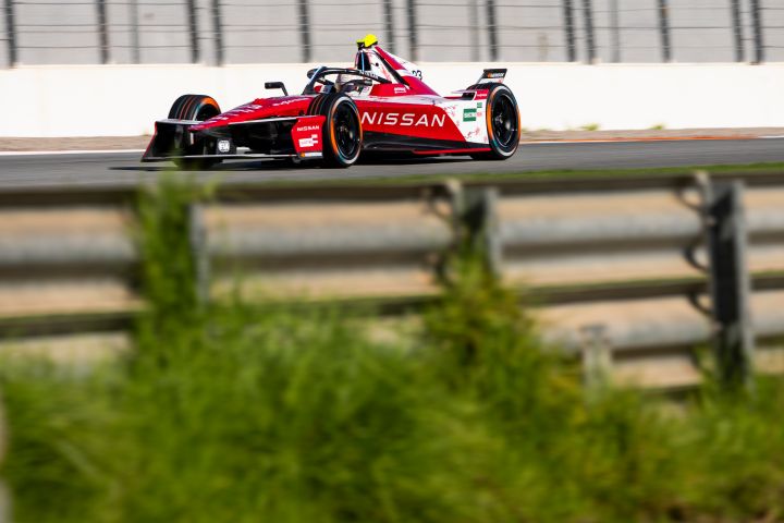 Das Auto mit der Nummer 23 auf der Rennstrecke in Valencia, fotografiert hinter einer Barriere, hinter der auch grünes Gras zu sehen ist.