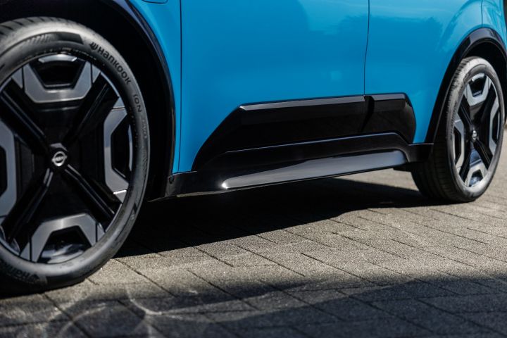 Detailansicht der unteren Seitenlinie eines blauen Nissan Micra mit schwarzem Element zwischen Vorder- und Hinterrad
