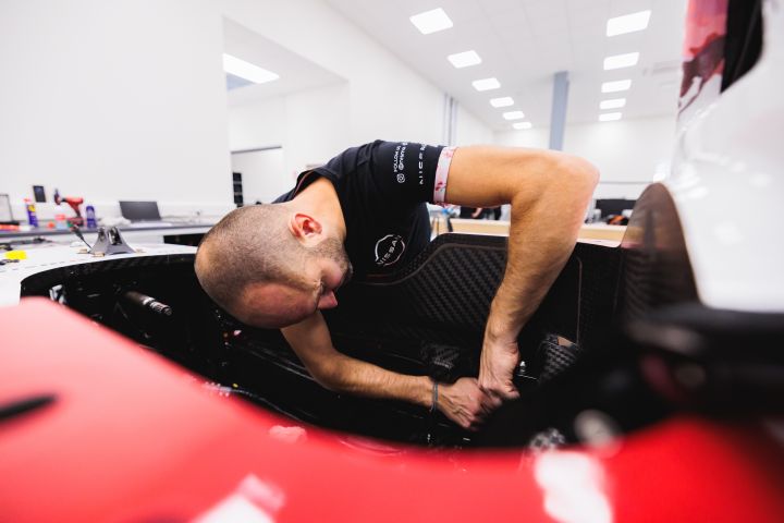 Ein Mechaniker beugt sich ins Innere des Nissan Formel E Rennwagens, um dort zu arbeiten