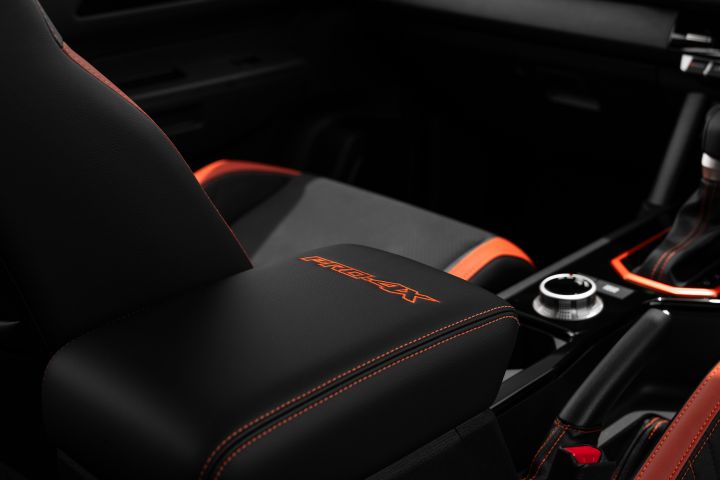 2026 Nissan Navara PRO-4X finished in Boulder Grey revealing the PRO-4X armrest, passenger seat base, metallic drive dial and red-edged shifter surround.