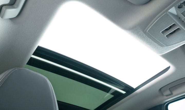 Interior view looking up at the Nissan Kicks sunroof. Bright sky is visible through the glass, expressing an open and airy cabin.