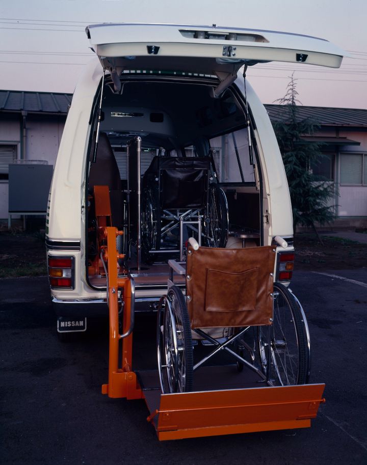 white caravan with an orange lift for wheelchairs coming out from the rear doors