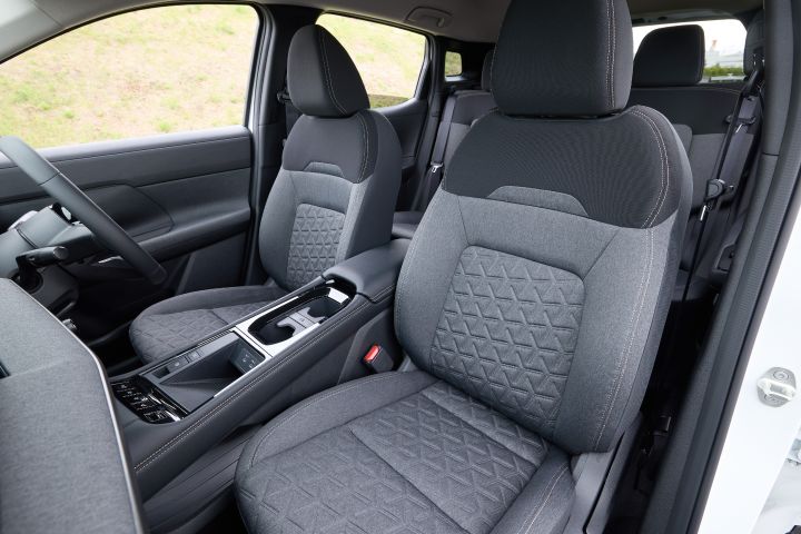キックスのフロントシート。黒基調のシートが並び、運転席と助手席が右向きに配置され、センターコンソールも確認できる室内カット。