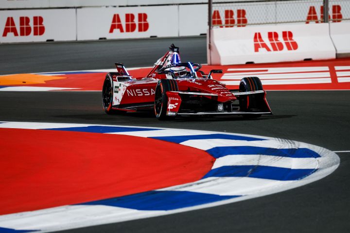 Oliver Rowland auf der Rennstrecke im Nissan Formel E Rennwagen mit der Nummer 23 während des E-Prix-Wochenendes in Jeddah, mit einer blau-weißen Bordsteinkante und weißer ABB-Werbung im Hintergrund.