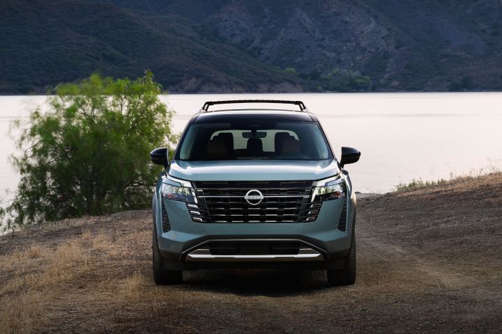 Front view of the 2026 Nissan Pathfinder parked in front of a body of water at dusk.