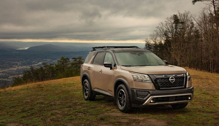 Nissan Pathfinder on a hill with cloudy weather.