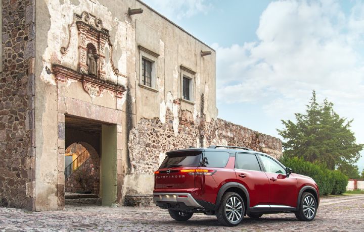 Nissan Pathfinder roja parte trasera y lado, como fondo una hacienda clásica de México