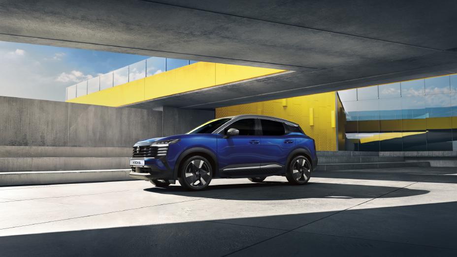 Side shot of the all-new Nissan KICKS in blue, parked under a yellow bridge.