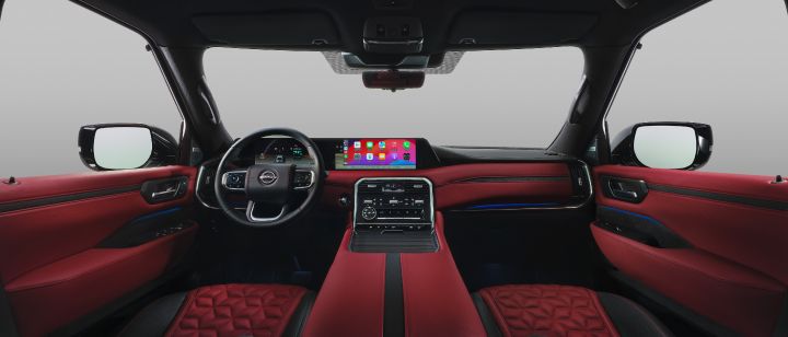 The interior of the Patrol viewed from the front seats. Red leather seats create a luxurious feel, and a large touchscreen-equipped dashboard is centrally positioned.