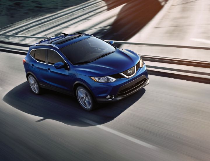 Un véhicule Nissan bleu roulant sur une route