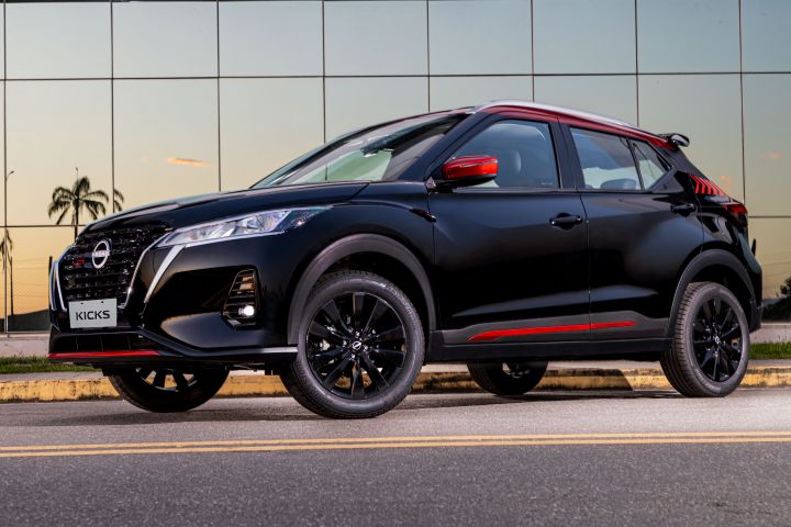 La Nissan Kick XPlay estacionada enfrente de un edificio con varios espejos.