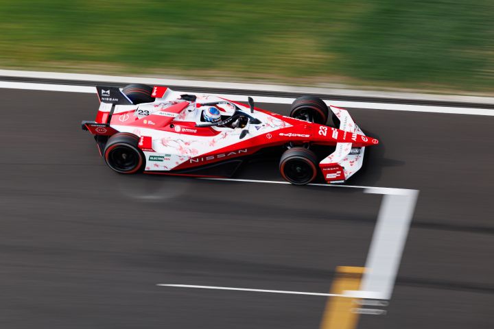 Photo from above of Oliver Rowland on-track in the #23 Nissan Formula E Team car in Shanghai with green grass visible at the top of the photo.