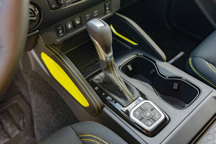 Close up of the gear shift and yellow interior details inside the 2027 Nissan Frontier Sport Edition.