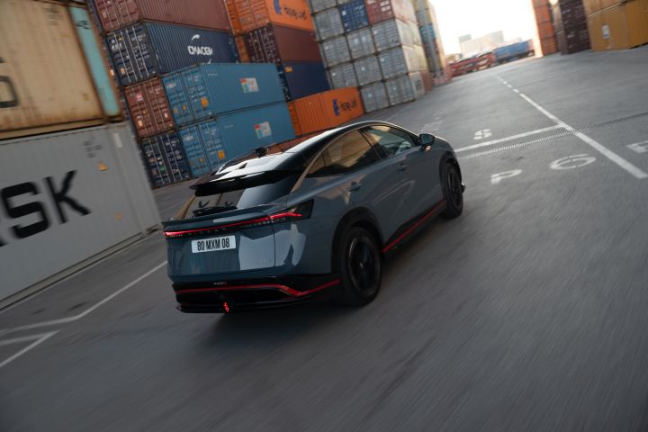 Dynamic shot from the rear of the Ariya NISMO as it drives around a bend