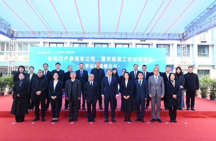Grupo de pessoas a posar à frente de placard com caracteres chineses