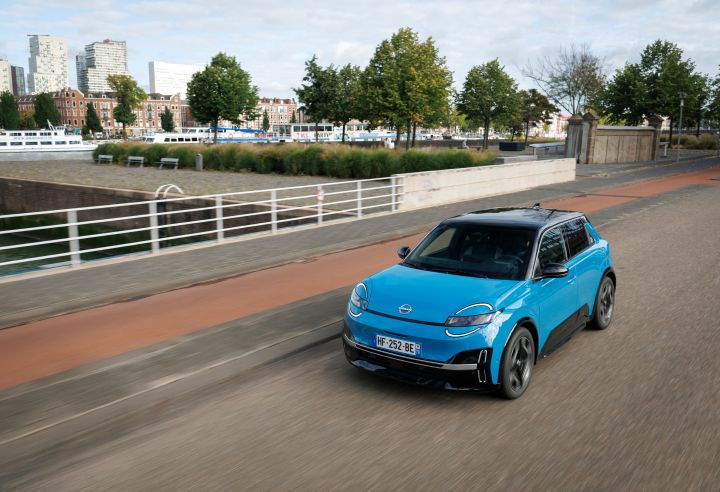 Erhöhter Blick von schräg vorne auf einen blauen Nissan Micra, der über eine Rotterdamer Straße fährt