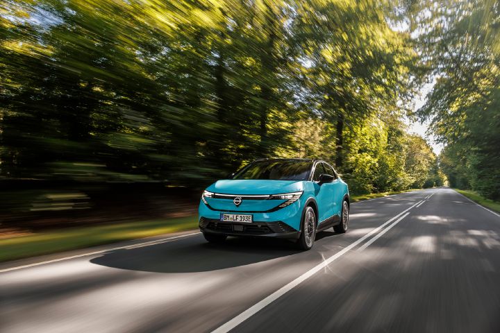 Dynamische foto van een Nissan LEAF schuin linksvoor in de kleur Luminous Teal