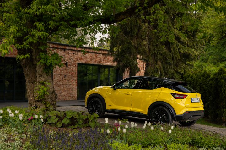 Żółty Nissan Juke stojący bokiem na tle budynku