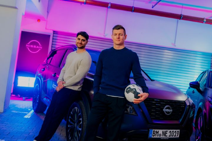 An einem Nissan X‑Trail lehnen die beiden Männer Elias Nerlich und Toni Kroos, letzterer hat einen Fußball in der Hand