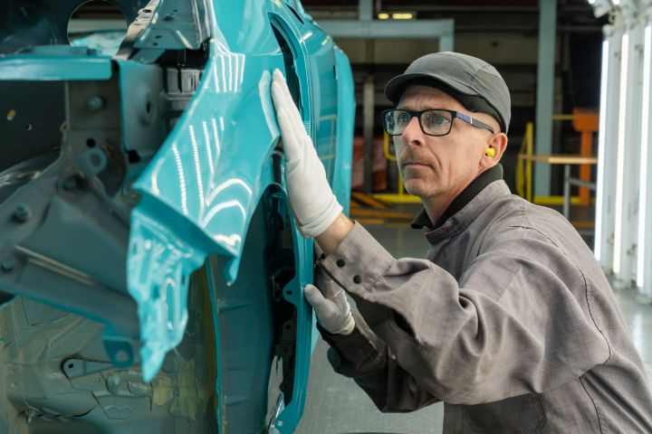 Ein Mitarbeiter kontrolliert die Lackierung eines neuen Nissan LEAF im Nissan Werk Sunderland