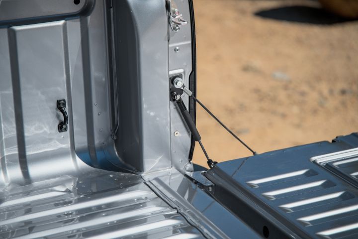 2026 Nissan Navara ST dual cab ute finished in Summit Silver with a close tray detail of the tailgate support cable, hinge area and ribbed cargo bed.